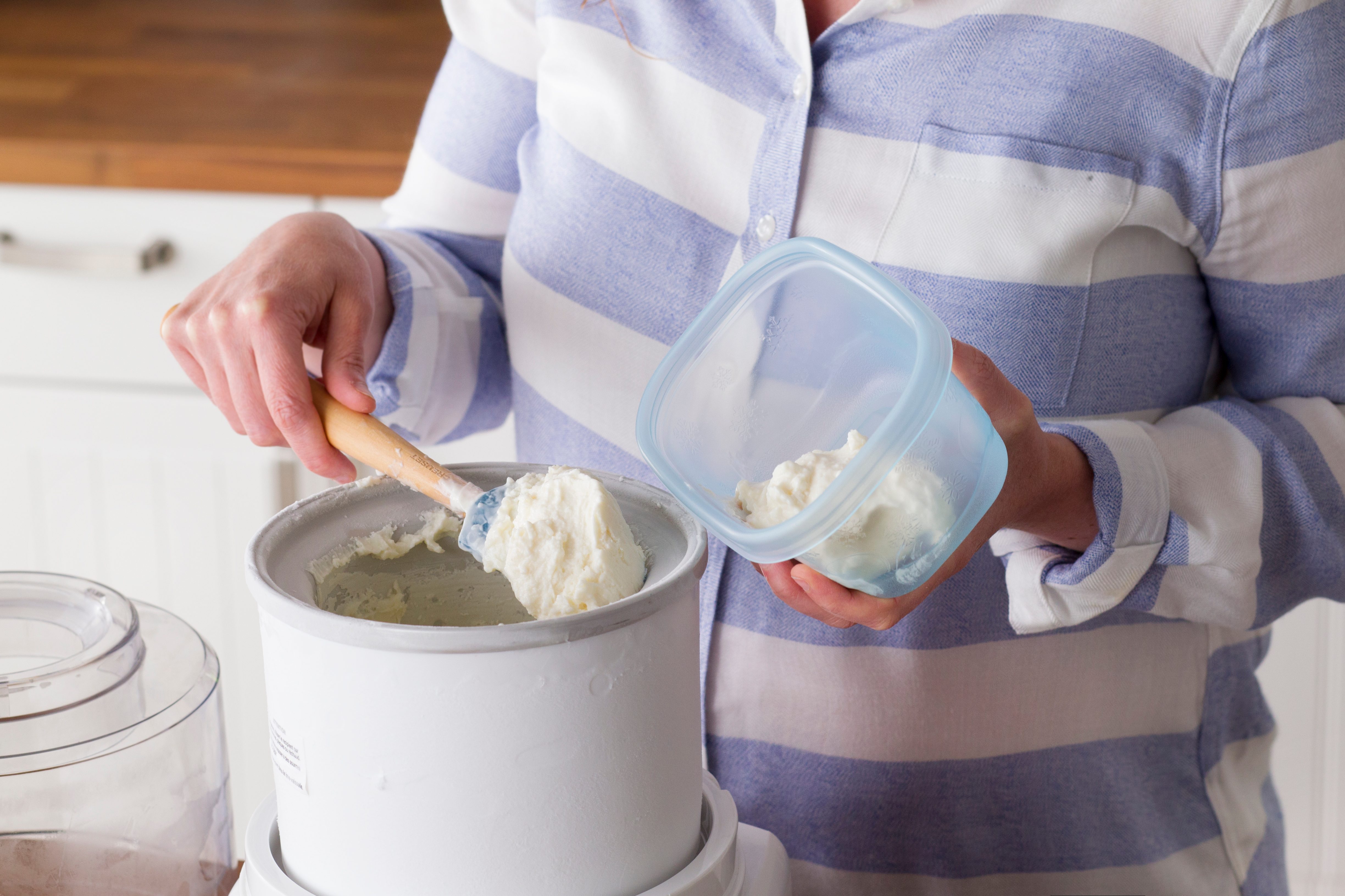 Now finished, the frozen yogurt is being removed from the ice maker and put into tuberware
