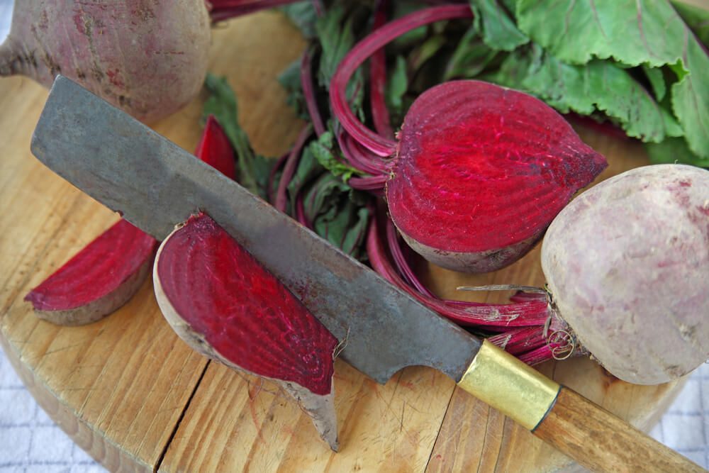 Beets, whole and cut, with old knife on cutting board