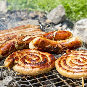 Sausages on grill outdoor. Grilling bratwursts on a charcoal grill