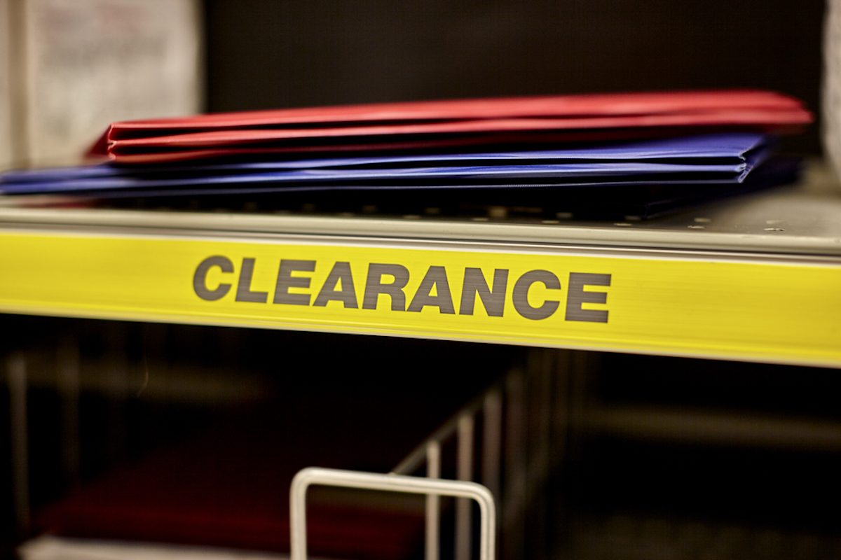 Red and blue folders on a clearance shelf in a retail store.