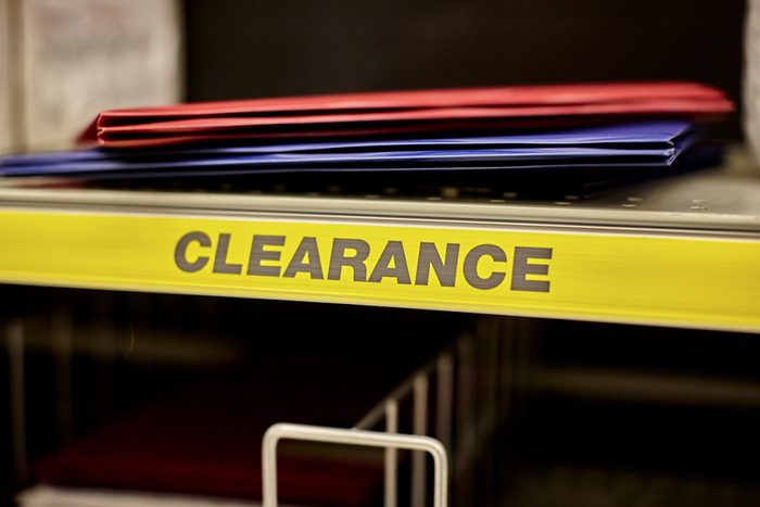 Red and blue folders on a clearance shelf in a retail store.