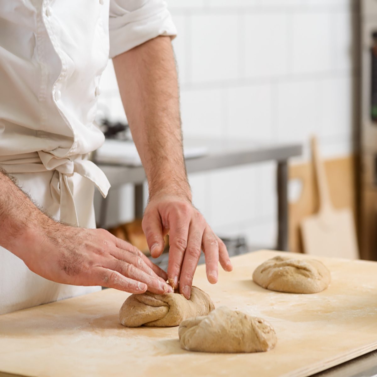 Baker is kneading dough made of whole wheat flour and forming loaves. Cooking bread for selling in the bakery store.