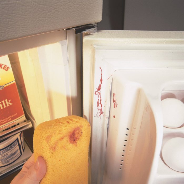 cleaning dirty fridge with sponge