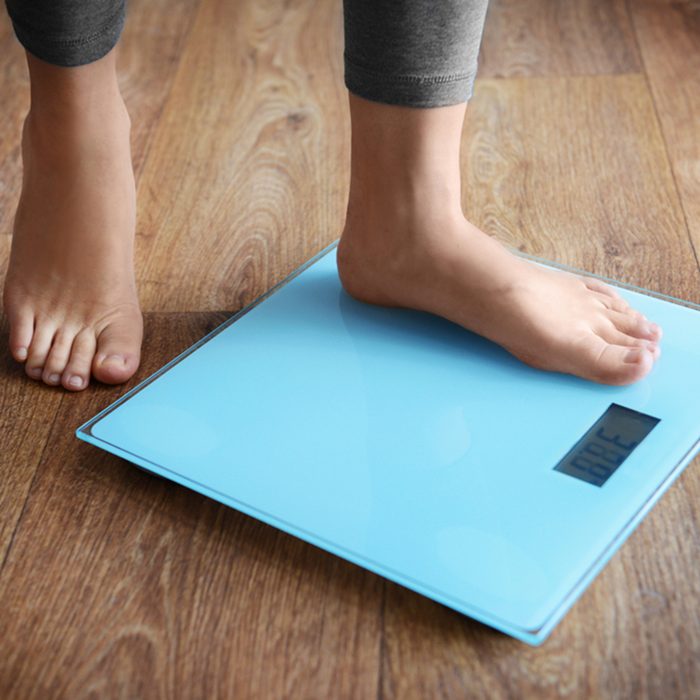 Female bare feet standing on a scales