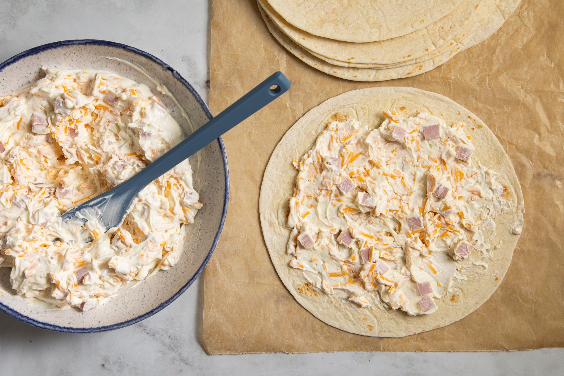 Ham And Cheese filling spread over the tortillas