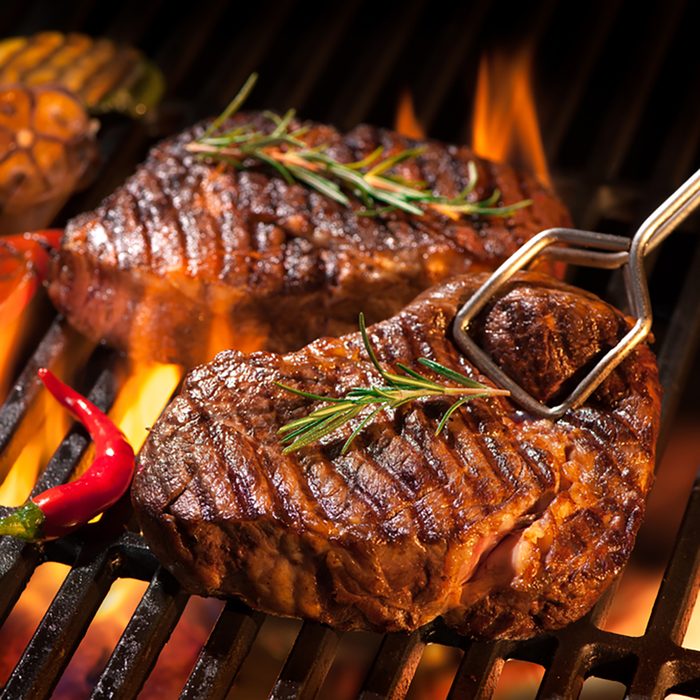 Beef steaks on the grill with flames