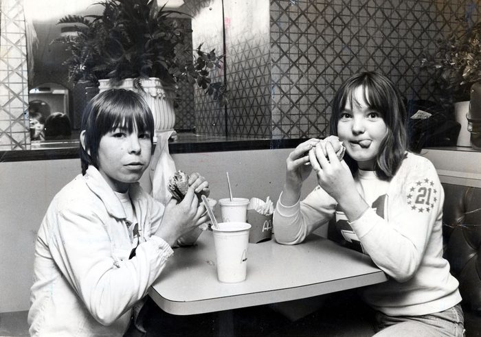 Two children eating hamburgers in McDonalds