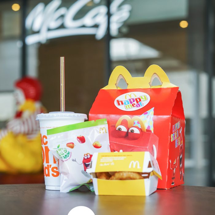 BANGKOK,THAILAND - JANUARY 9,2018 : Happy meal set on desk ,in soft focus, with blurred Ronald McDonald at McDonald