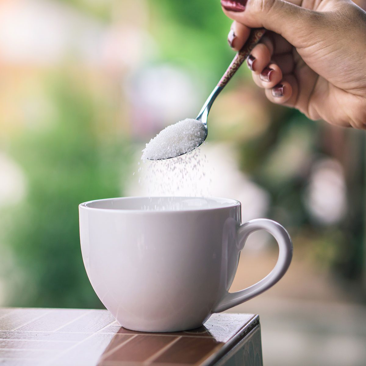 sugar alternatives Unhealthy Woman Hand Holding Spoon Pouring Sugar 1205964143 Square