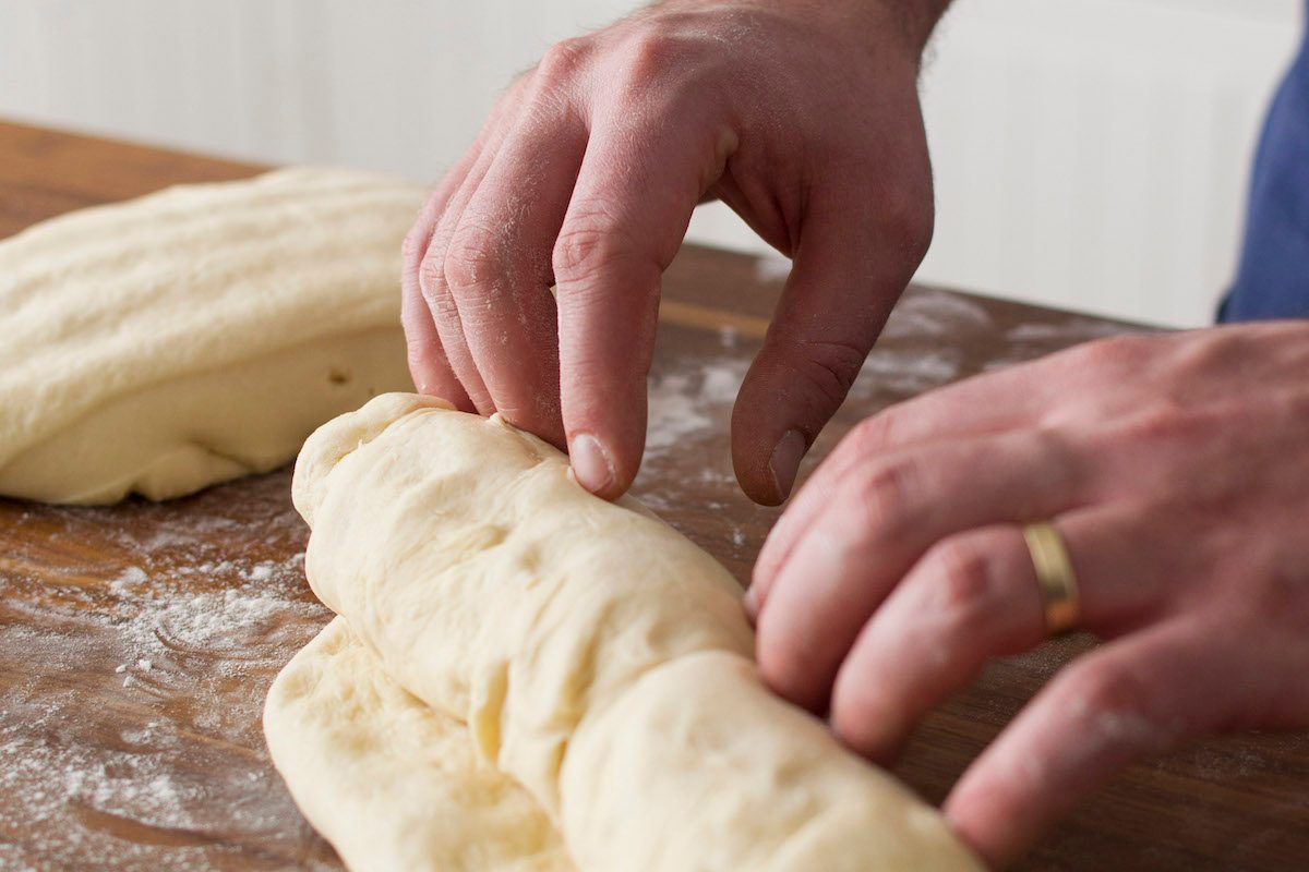 A person kneading sourdough to make a loaf homemade sourdough bread.