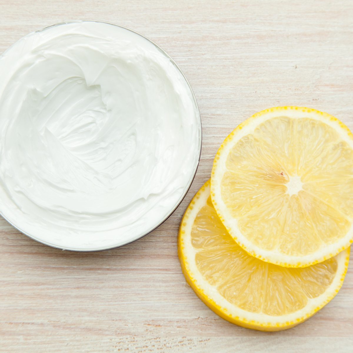 body cream and lemon slices on the wooden table