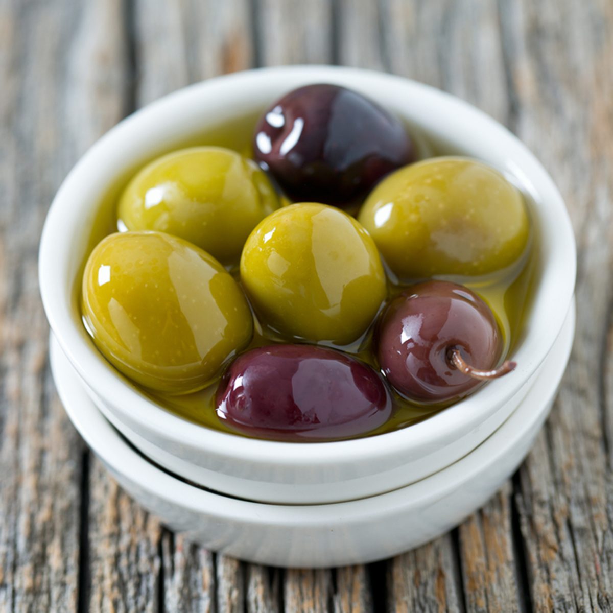 olives in a bowl on wooden surface