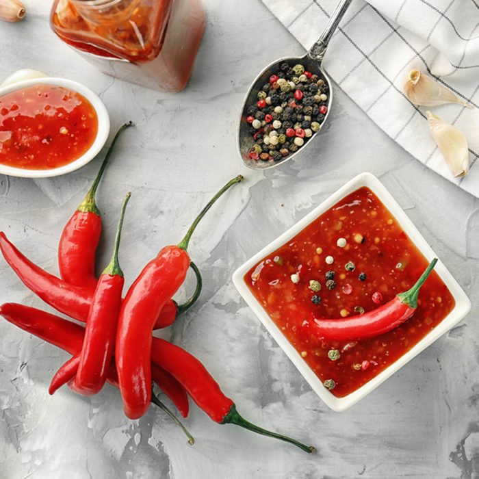 Composition with tasty chili sauce in bowl on table