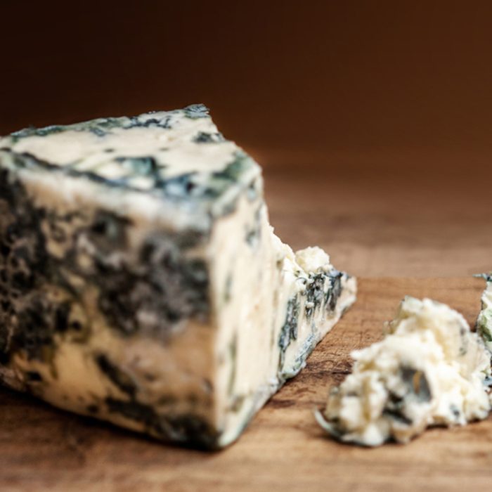 Blue cheese Gorgonzola on a rustic wooden background.