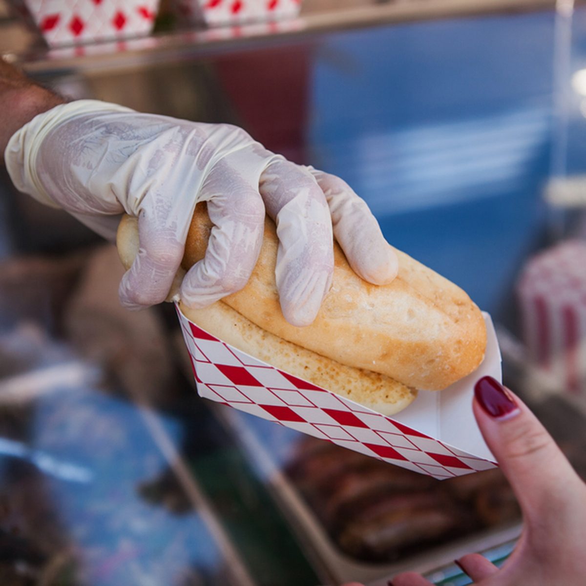 Street stall to sell hot dogs. Customer holding a hot dog purchased. ; Shutterstock ID 328465880