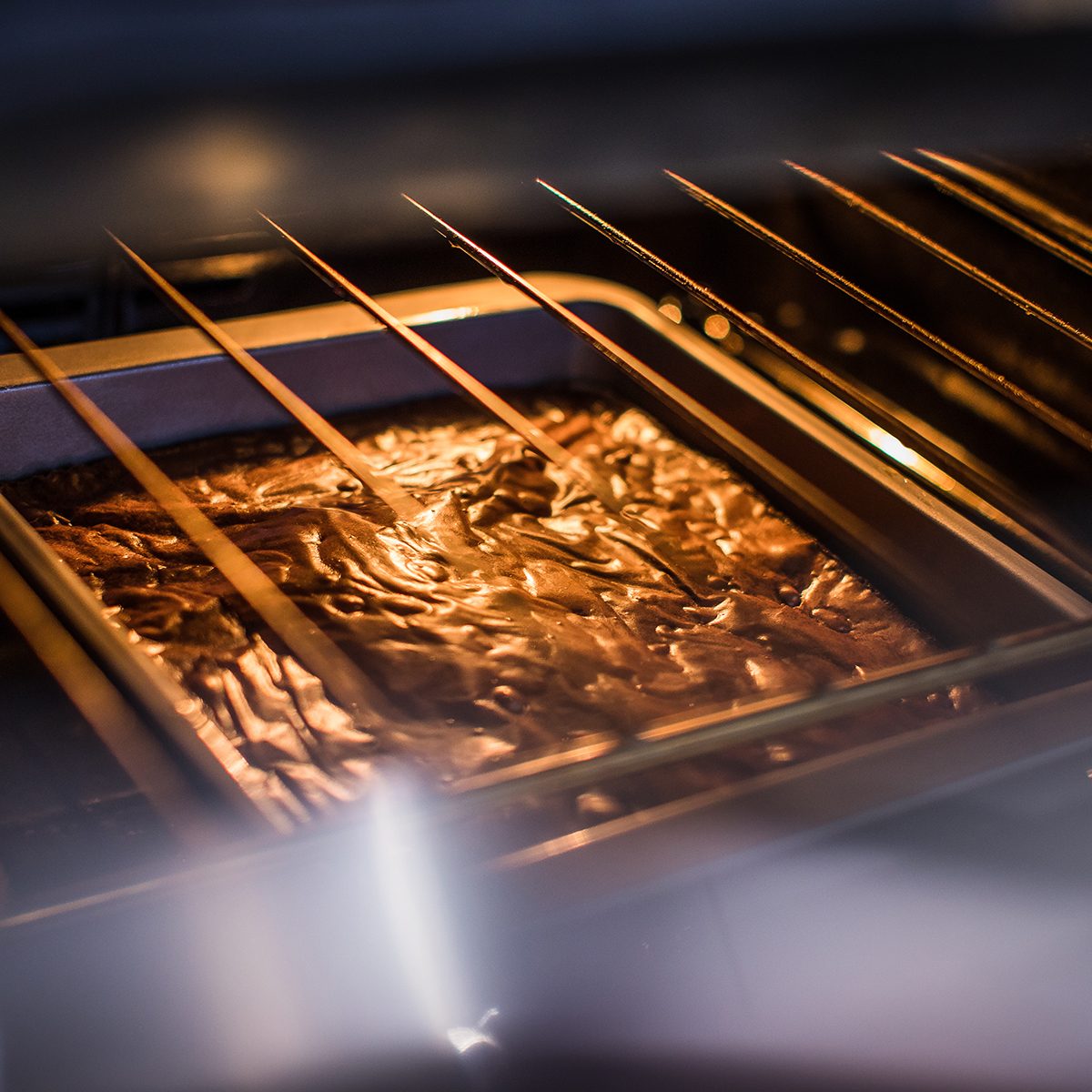 Brownie cake mixture on the middle shelf of a hot oven