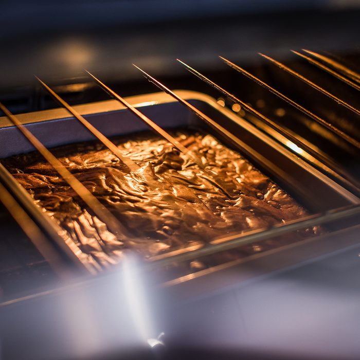 Brownie cake mixture on the middle shelf of a hot oven