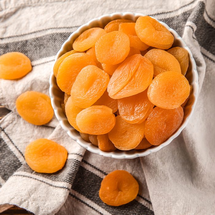 Bowl with dried apricots on table