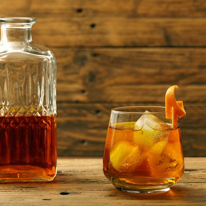 cocktail drink wiskey and orange on rustic background