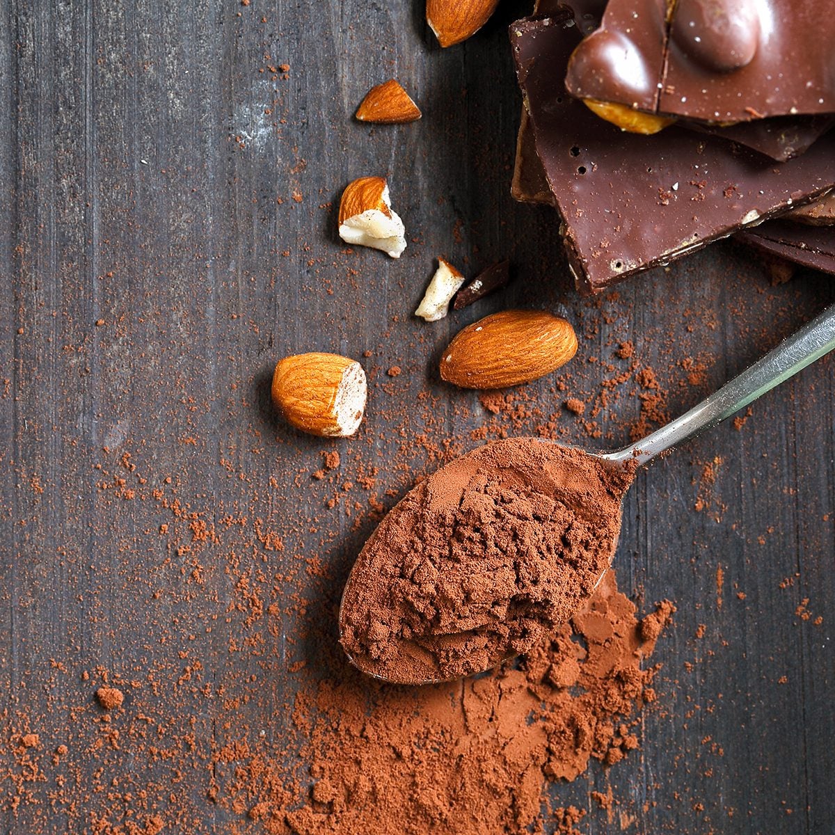 Cocoa Powder and Dark Chocolate almond on black wood table
