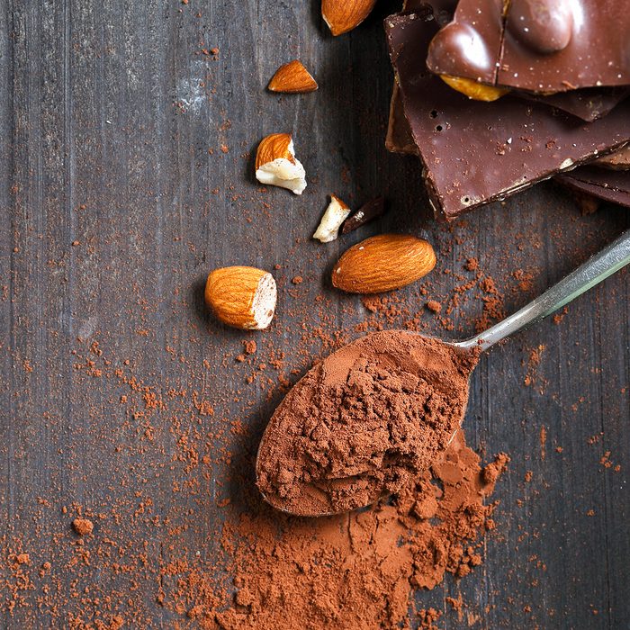 Cocoa Powder and Dark Chocolate almond on black wood table
