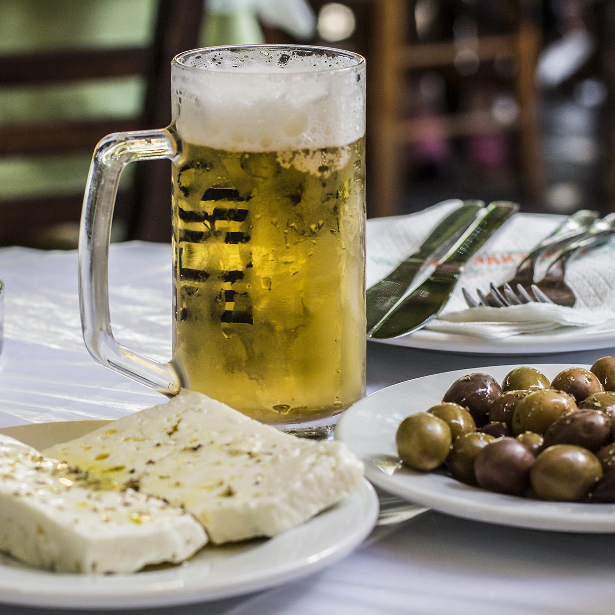 Greek famous food: cheese and olives with a glass of beer on the table, Athens, Greece