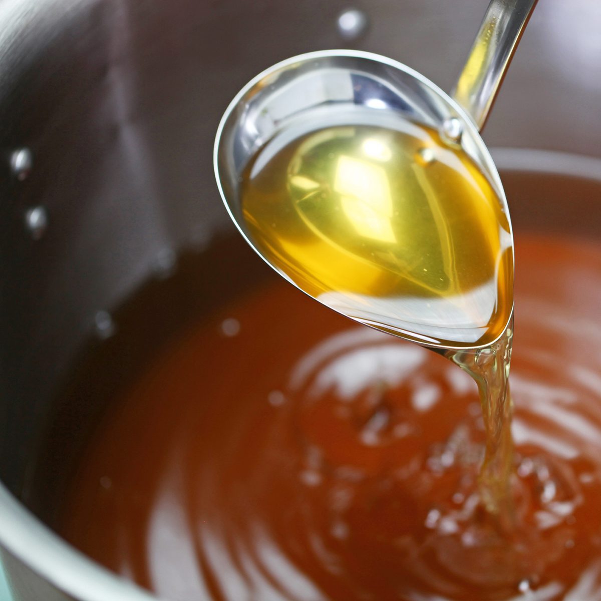 making chicken consomme soup in a pot