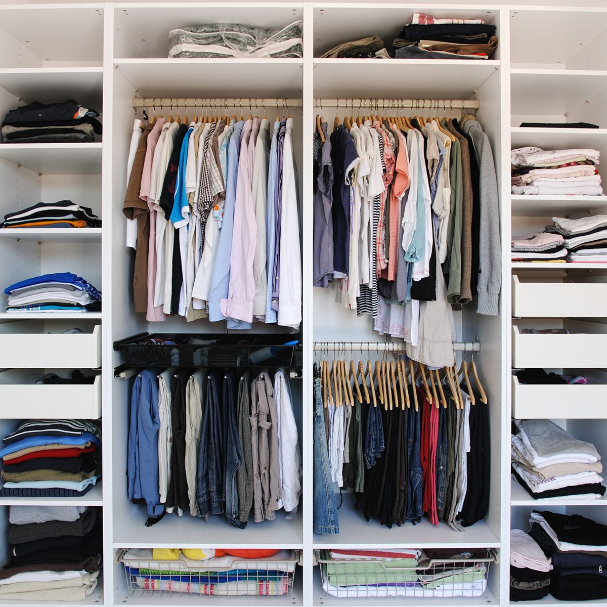 Open wardrobe inside. Men an women clothes.