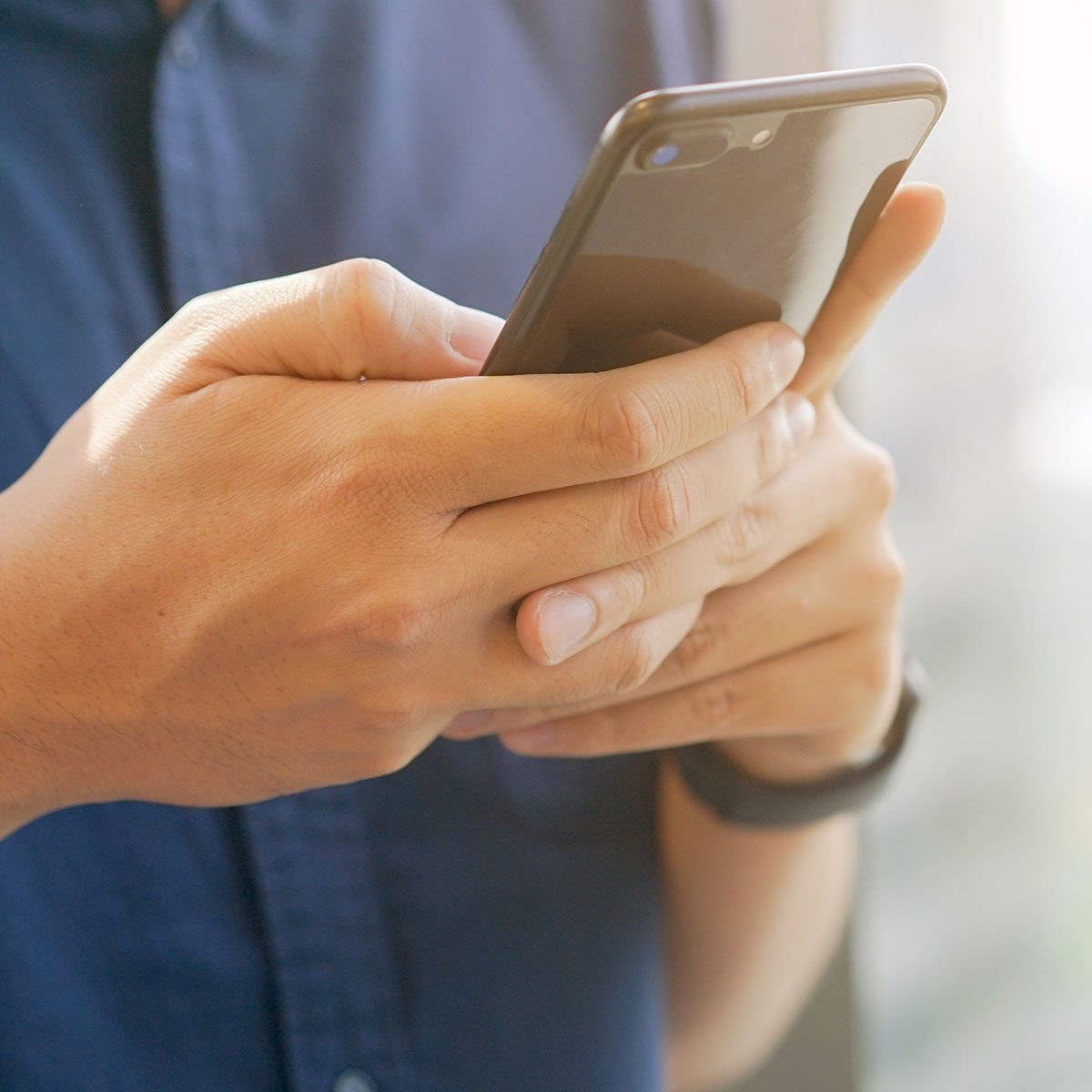 close up businessman holding smartphone for checking work or make appointment and using application for manage job or surf the internet at outside office , technology lifestyle concept