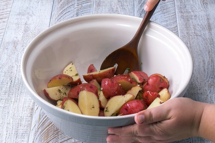 Tossing the Potatoes in Oil, rosemary and salt