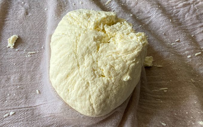 strained paneer in the cheese cloth ready to be flattened