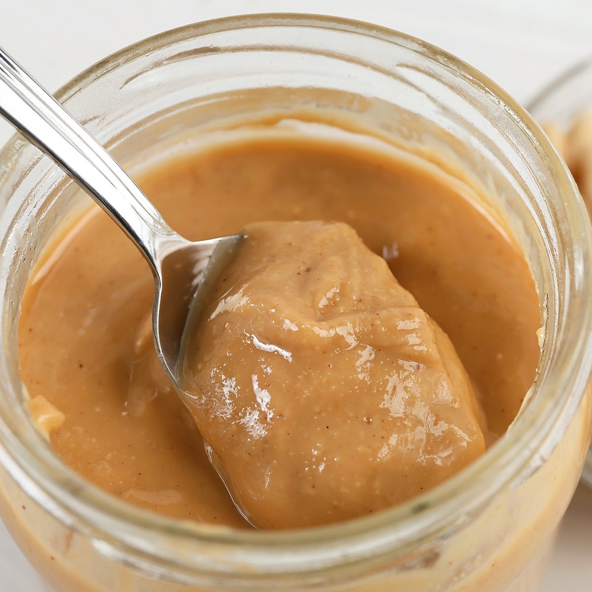 peanuts and peanut butter in a jar on the table close-up