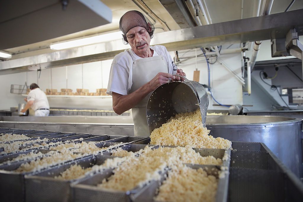 John Christopherson pours Brick cheese curds into forms at the Widmer's Cheese Cellars on June 27, 2016 in Theresa, Wisconsin.