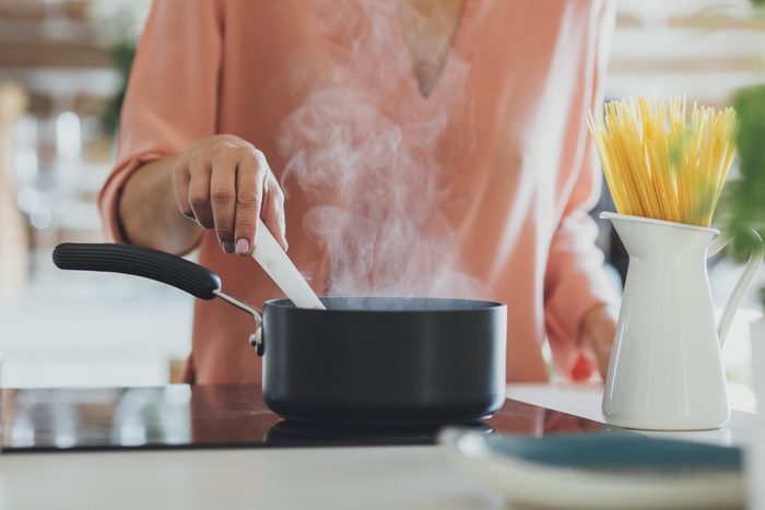 Older Caucasian woman cooking in kitchen