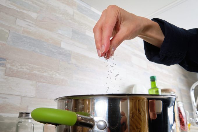 Cooking Italian pasta with cream sauce and Basil, at home. A girl or woman Cooks and Stirs Penne Pasta in a Pot. Vegetarian food. Step-by-step instructions, do it yourself. Step 4.