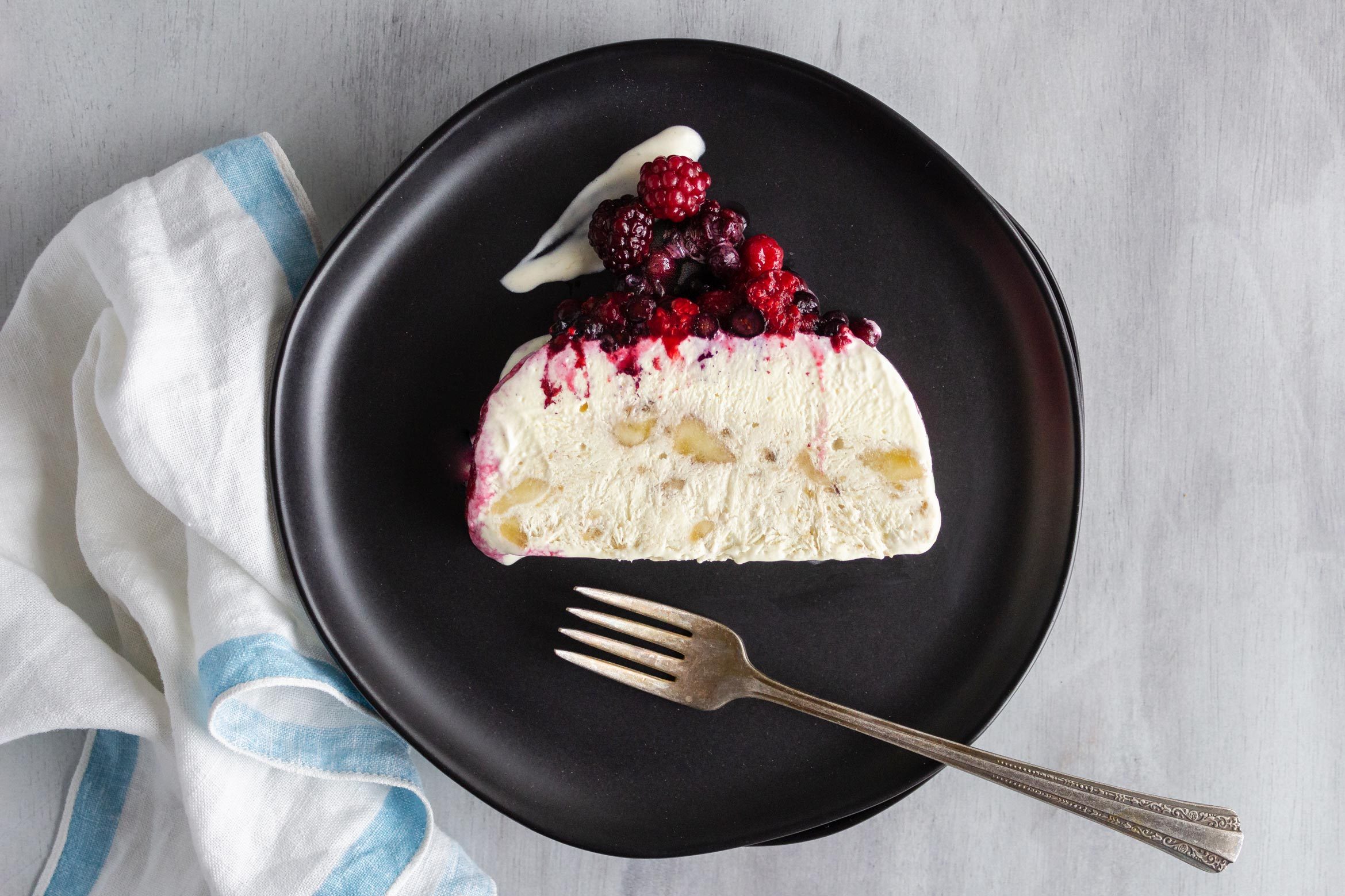 slice of Jello Frozen Pudding Dessert from 1968 with berries on a black plate
