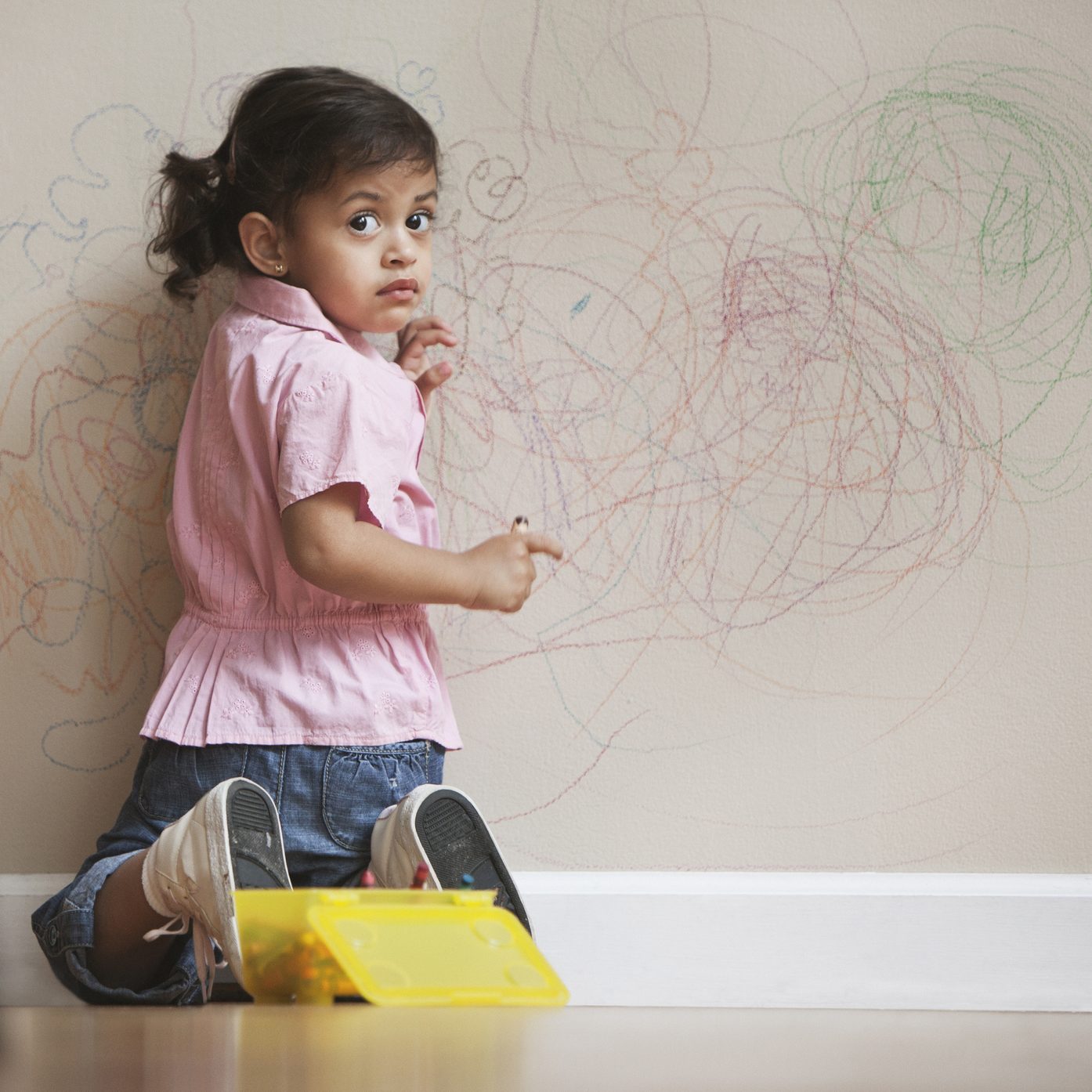 Hispanic girl drawing on wall