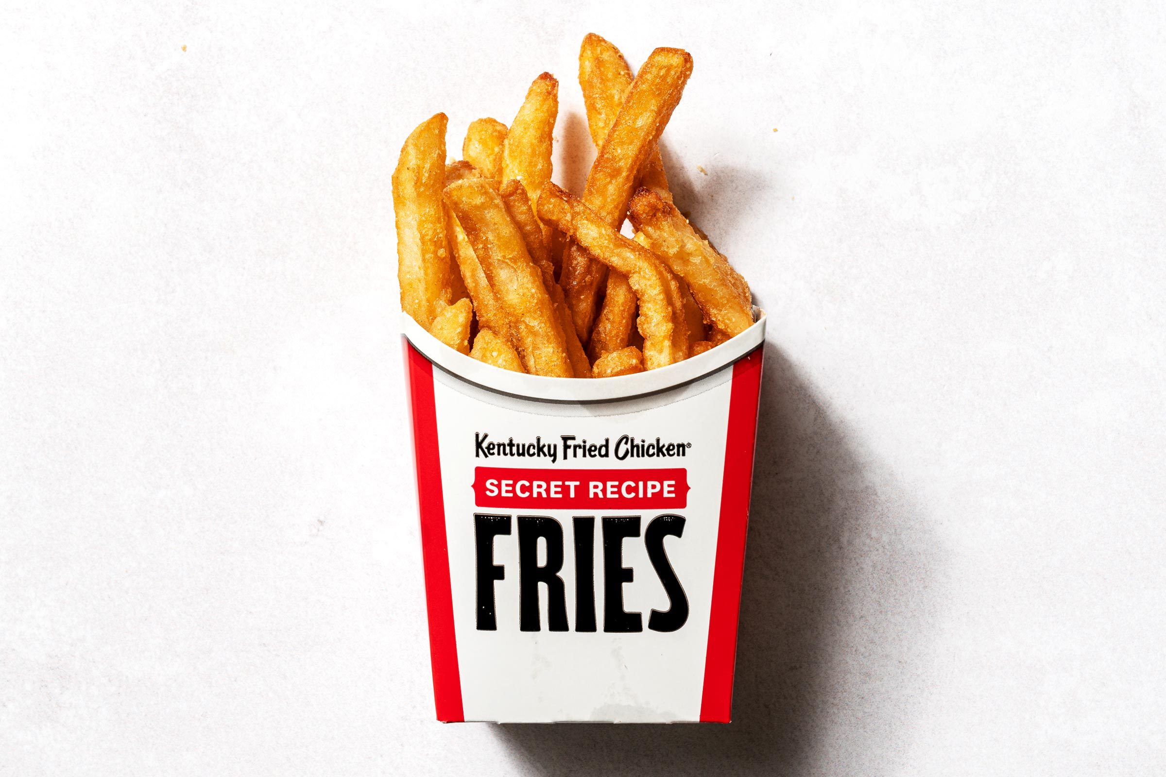 KFC fries in a cardboard cup that says kentucky fried chicken secret recipe fries