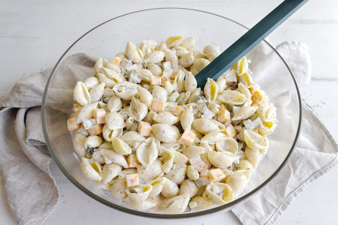 dill pickle pasta salad in a large glass bowl, view from above