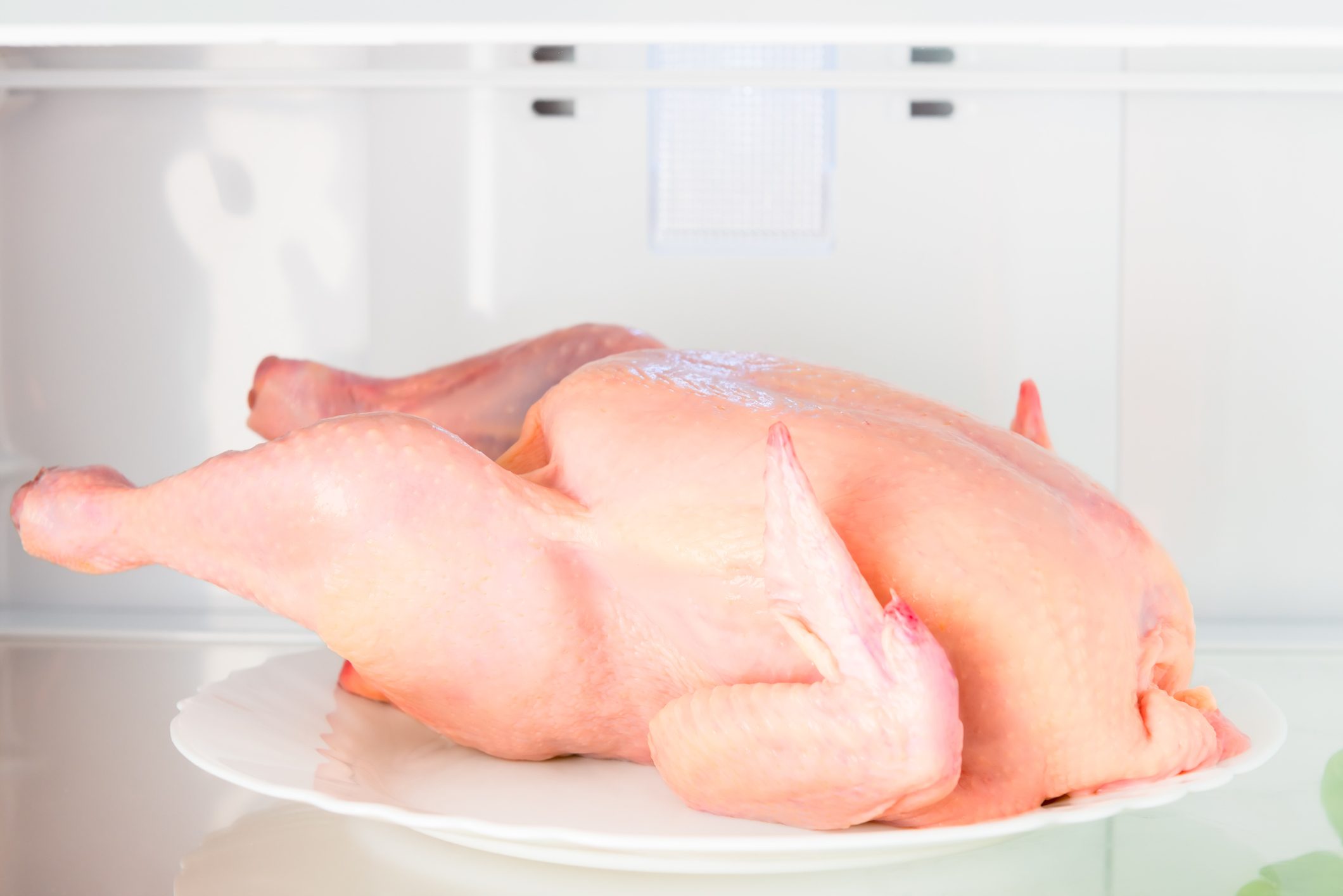 raw chicken on the shelf of the refrigerator
