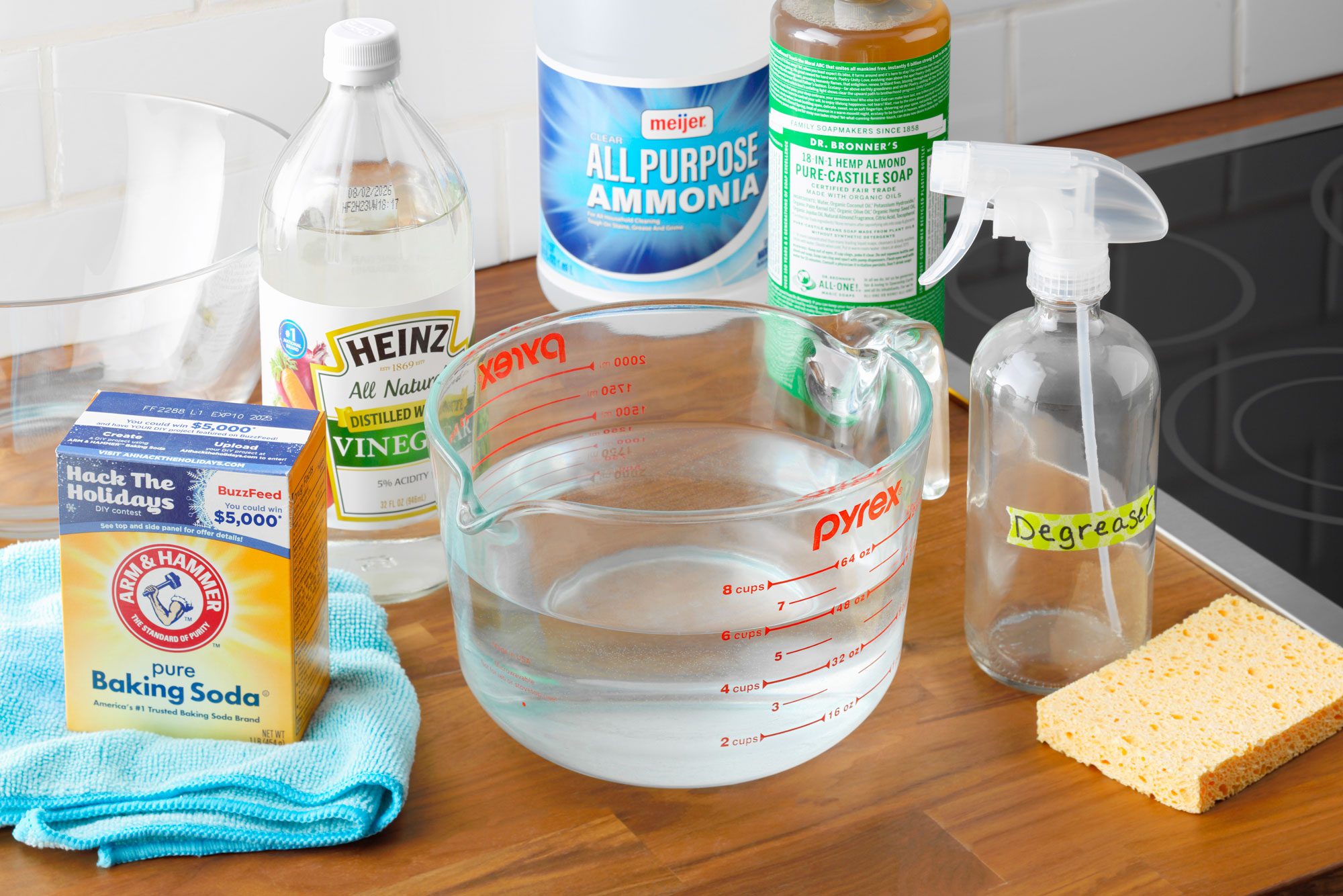 Homemade Cleaner degreaser ingredients arranged on a kitchen counter near a stove top