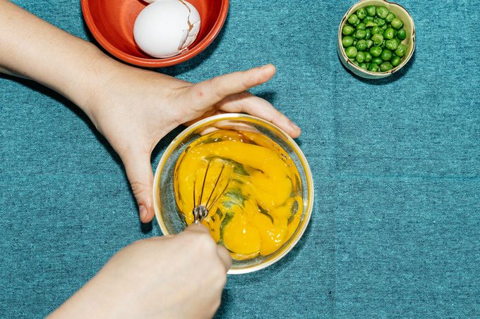 whisking an egg in a small glass bowl