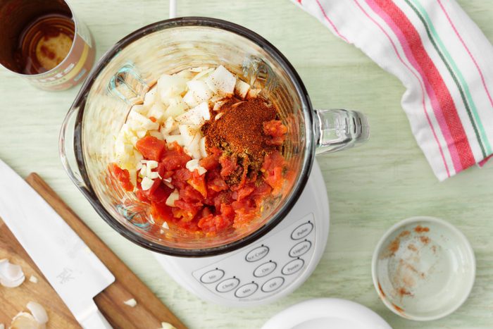 food processor with tomatoes, onion, garlic and seasonings