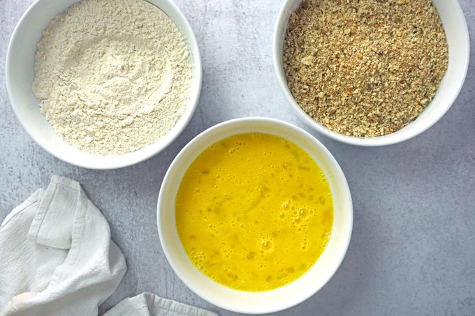 three bowls with ingredients for coating Mozzarella Sticks before frying
