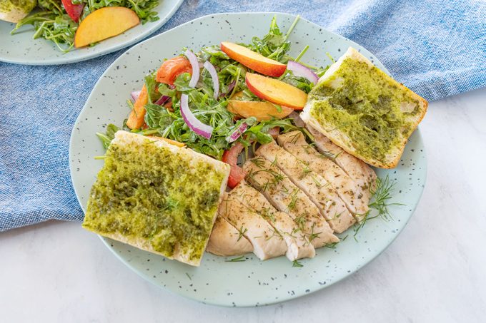 Herbed Chicken with Nectarine Summer Salad and Pesto Bread served on a plate
