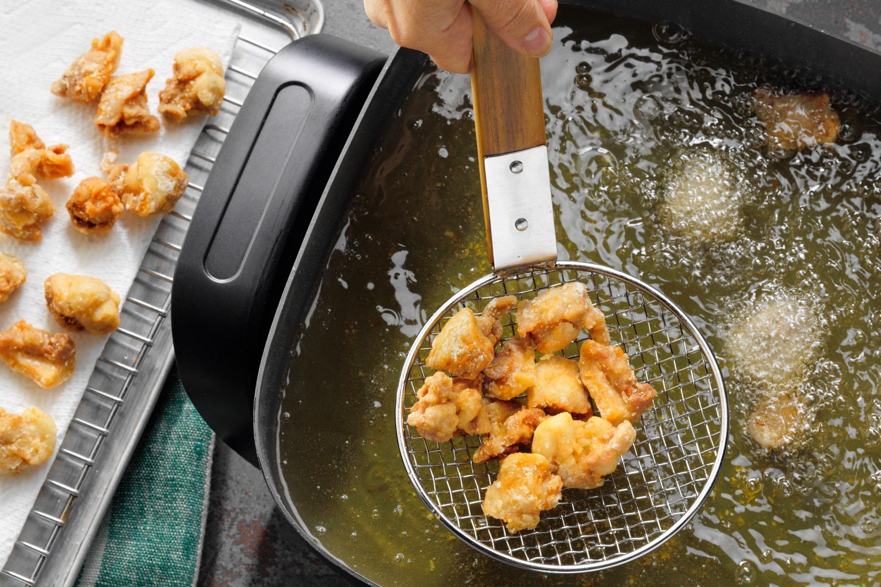A Person Holding a Metal Strainer With Food in It