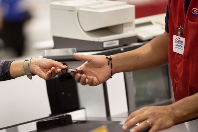 Mayra Guitierrez hands the cashier her membership card to make purchases at the Costco in Huixquilucan, Estado de Mexico