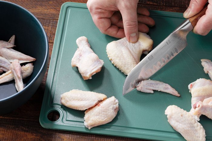 A person using knife to separate the wings