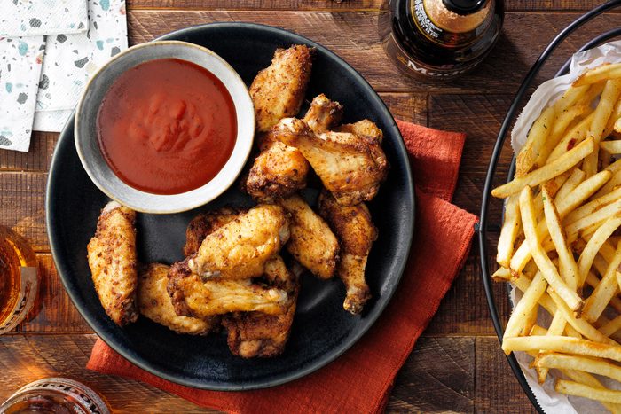 Air Fryer Chicken Wings served in a plate with sauce and french fries