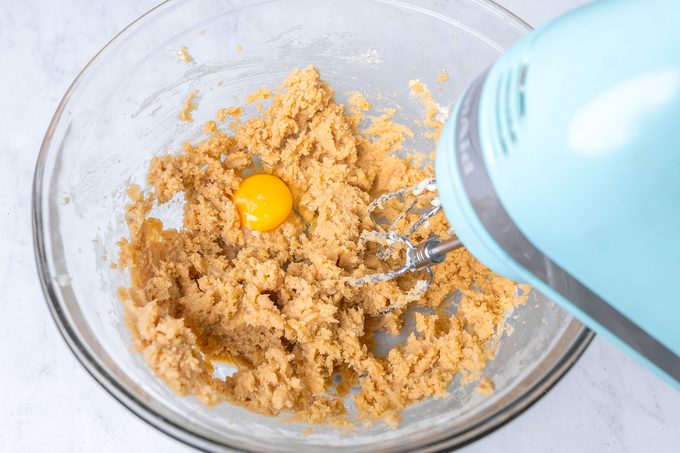 Mixing Kitchen Sink Christmas Cookies Dough in a Large Glass Bowl with Hand Mixer
